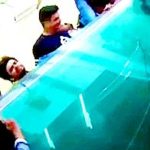 Trzech facetów przygniecionych przez tafle szkła.