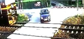 Kierowca wyjeżdża przed pociąg na zamkniętym przejeździe.